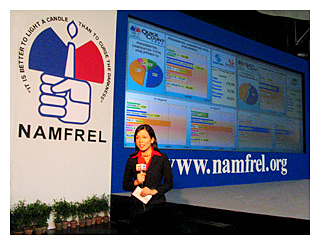 a news reporter relays  the latest quick-count poll results from the Namfrel