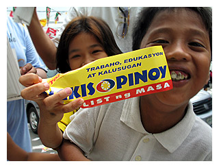 This bumper sticker says "Jobs, education and health care" if the Bigkis Pinoy partylist wins. (This little boy needs dental attention right away)